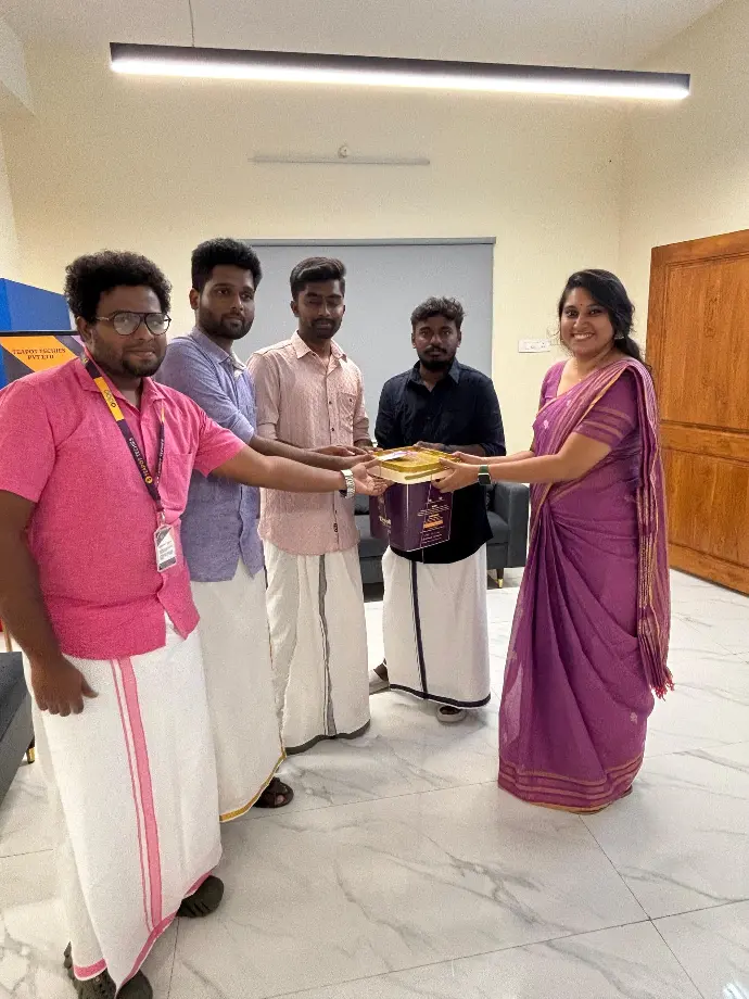 Managing Director handing over a gift to a teammate in traditional dress