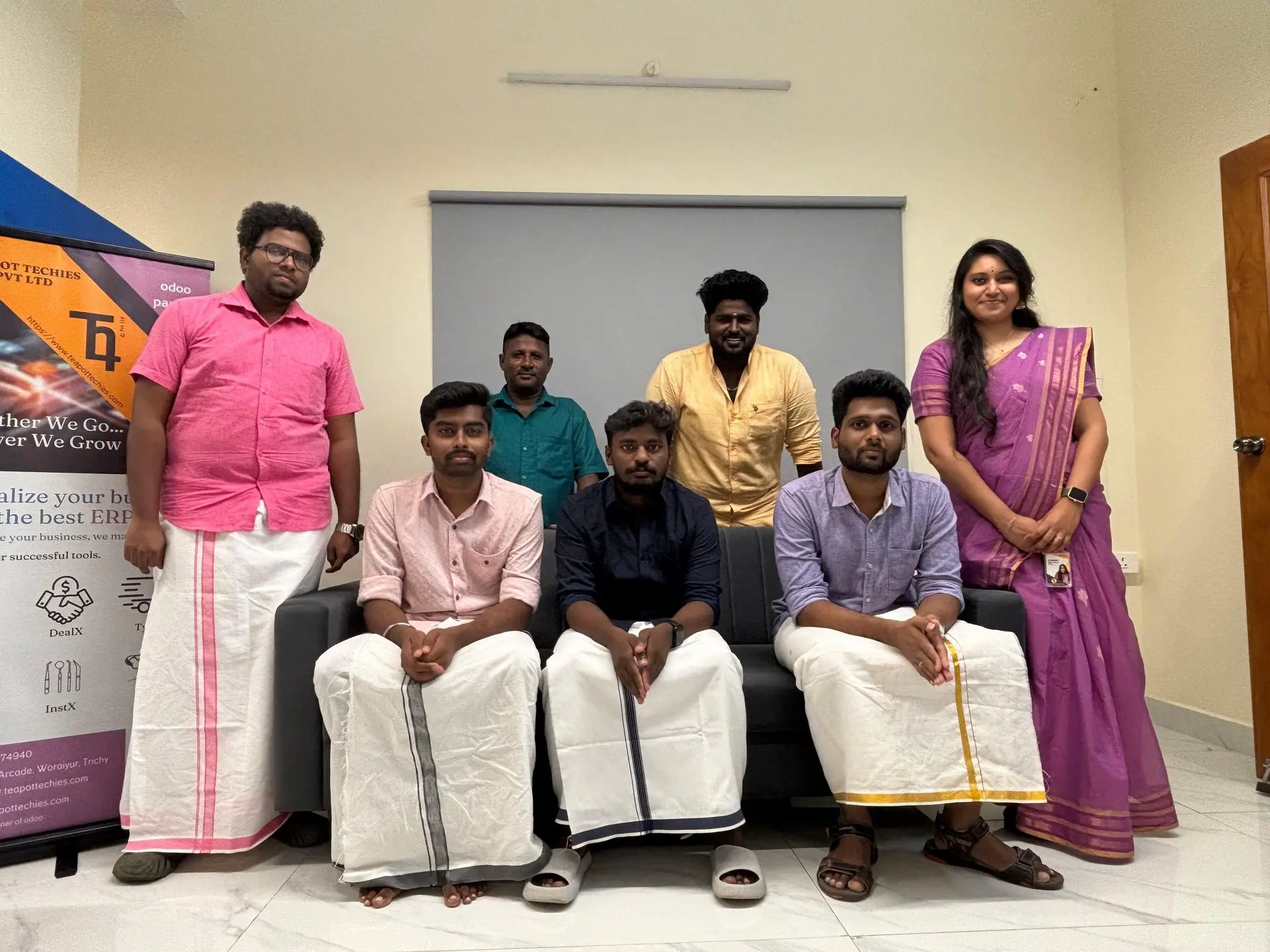 The whole team in traditional dress posing on the lounge sofa