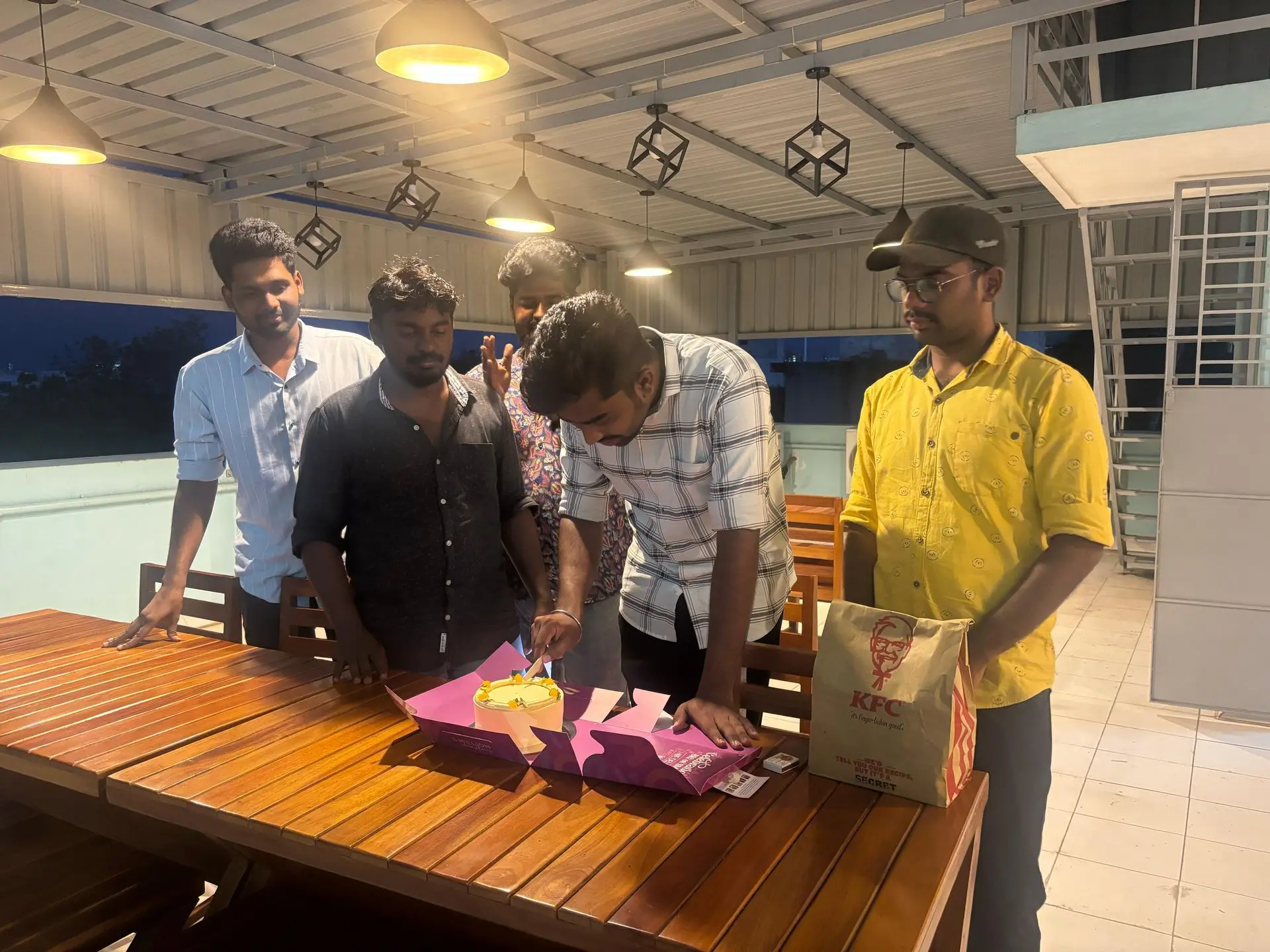 Teammates unwrapping gifts at the terrace table