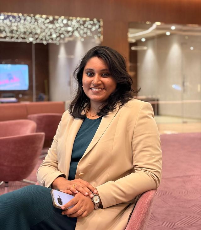 Smrithi Suresh seated in a hotel lounge, wearing a beige blazer