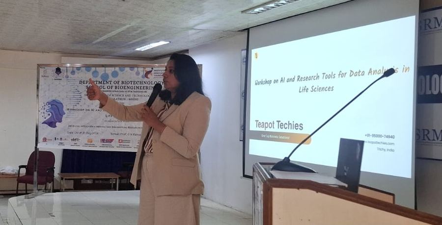 Smrithi speaking beside the workshop banner of the Department of Biotechnology, SRM